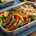 Beef and vegetable stir fry meal prep bowls with bell peppers, broccoli, carrots, and brown rice