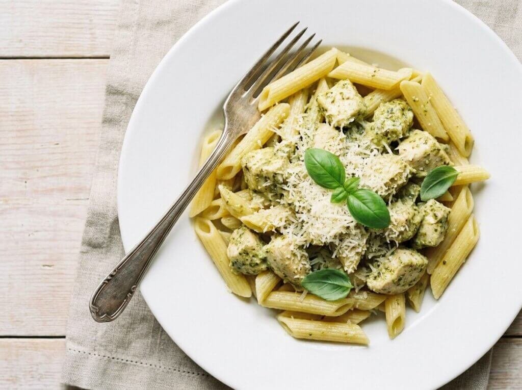Creamy pesto chicken pasta topped with Parmesan and basil